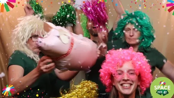 Des invités en perruques brandissent un cochon gonflable
